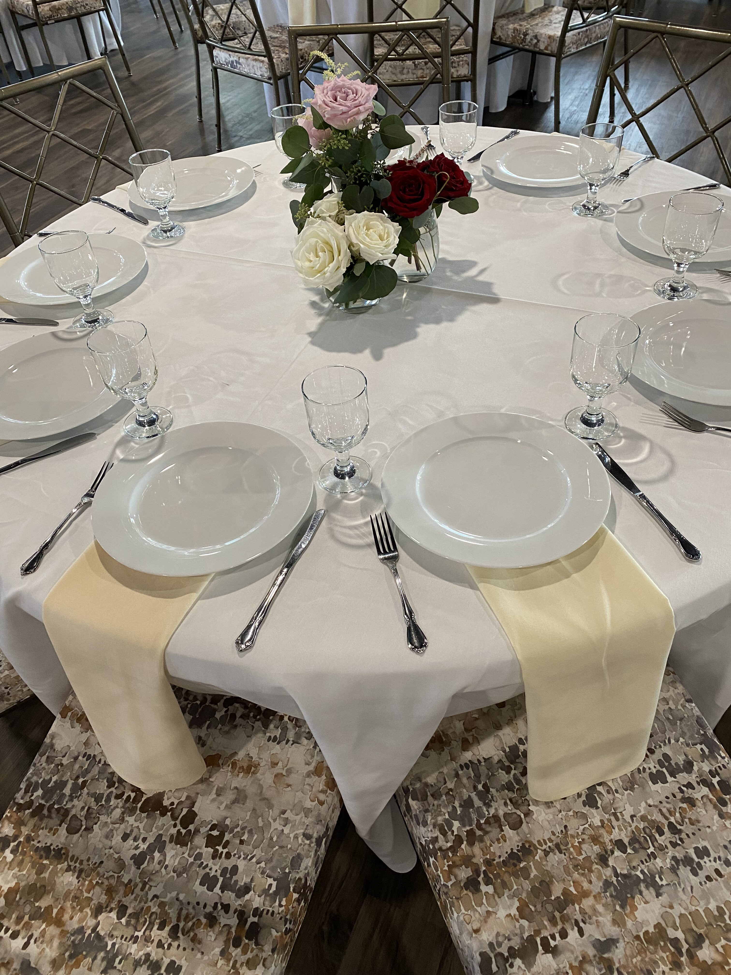 White table cloth on a circular table with a floral centerpiece